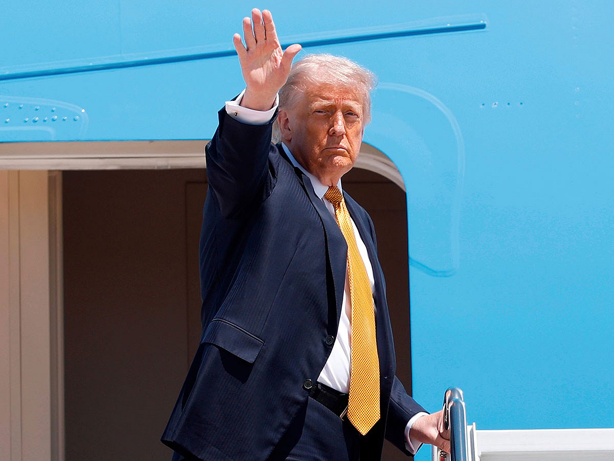 President Donald Trump waves from the stairs of Air Force One as he boards upon his arrival at Joint Base Andrews, Md.,, for a trip to China to meet President Xi Jinping.