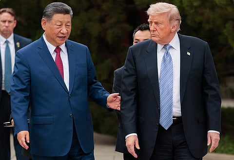 US President Donald Trump (R) walks with China’s President Xi Jinping (L) as he leaves after a visit to Zhongnanhai Garden in Beijing on May 15, 2026.