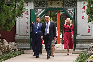 US President Donald Trump (2nd R) walks with China’s President Xi Jinping (L) at the Zhongnanhai leadership compound in Beijing on May 15, 2026.