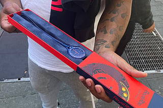 A customer shows his newly purchased Audemars Piguet x Swatch Royal Pop watch outside of a Swatch store in Times Square in New York on May 16, 2026.