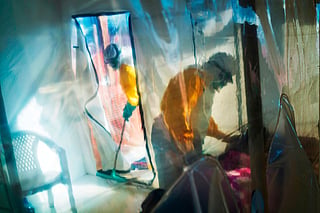 FILE - Health workers wearing protective suits tend to an Ebola victim kept in an isolation tent in Beni, Congo, July 13, 2019. (AP Photo/Jerome Delay, File)