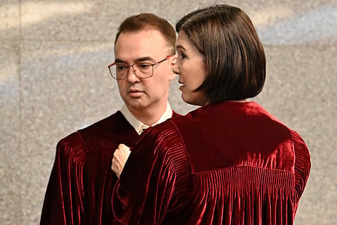 Philippine Senator Pia Cayetano (right), elder sister of former Senate President and chief judge Alan Cayetano, fixes the robes of her brother prior to taking their oath as jurors in the impeachment trial of Vice President Sara Duterte at the plenary hall of the Senate in Manila. File photo taken on May 18, 2026.