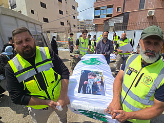 Officials carry the bodies of victims killed in the Israeli strike on the southern village of Deir Qanoun al-Nahr, outside Jabal Amel Hospital in the Tyre area of south Lebanon, before the bodies were transferred to their hometown for burial, as security conditions prevented families from holding the farewell ceremony in the village. File photo taken on May 21, 2026.