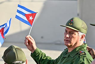 Cuba's President Miguel Diaz-Canel holds a Cuban flag during a rally in support of former Cuban president Raul Castro, 94, who has been indicted by a US court, outside the US Embassy in Havana on May 22, 2026.
