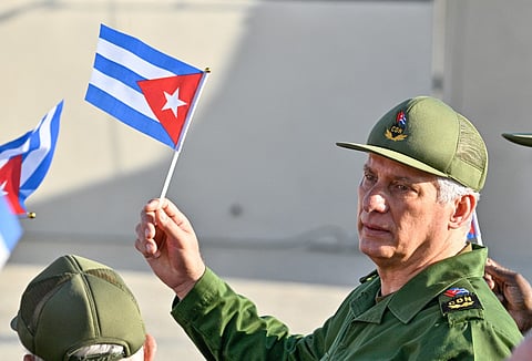 Cuba's President Miguel Diaz-Canel holds a Cuban flag during a rally in support of former Cuban president Raul Castro, 94, who has been indicted by a US court, outside the US Embassy in Havana on May 22, 2026.