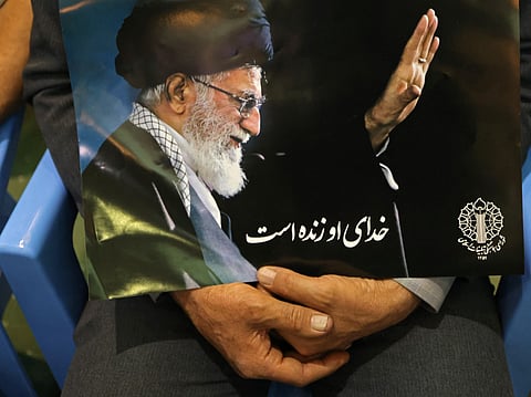 An Iranian man holds the image of the late assassinated supreme leader Ali Khamenei during a gathering at the Imam Khomeini Mosque (Mosalla) to commemorate those killed in former wars and also those killed during the latest US-Israel led war, in Tehran on May 24, 2026.
