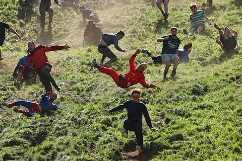 Thrill-seekers tumble to glory in 'bonkers' UK cheese-rolling race
