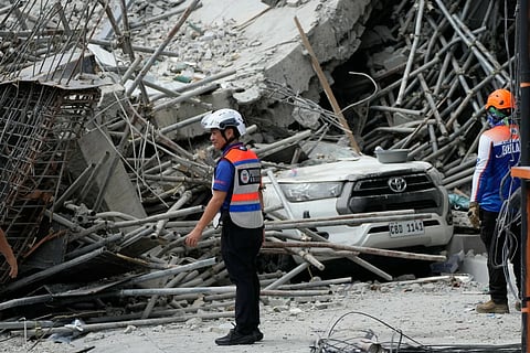 Rescuers stand beside ruins as search operations continue in a collapsed building in Angeles City in Pampanga, Monday, May 25, 2026.