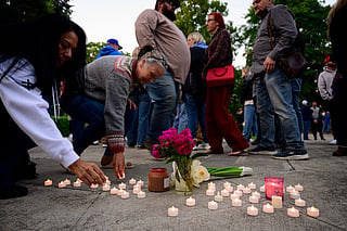 Community members place electric candles near a vase of flowers during a vigil at R.A. Long Park following a fatal chemical storage tank failure on May 26, 2026 in Longview, Washington.