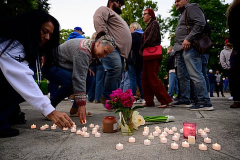 Community members place electric candles near a vase of flowers during a vigil at R.A. Long Park following a fatal chemical storage tank failure on May 26, 2026 in Longview, Washington.
