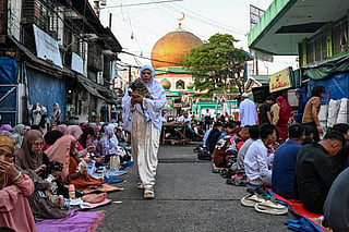 A woman walks outside the Golden Mosque as Muslims gather to celebrate the Muslim festival of Eid al -Adha in Quiapo, Manila on May 27, 2026.