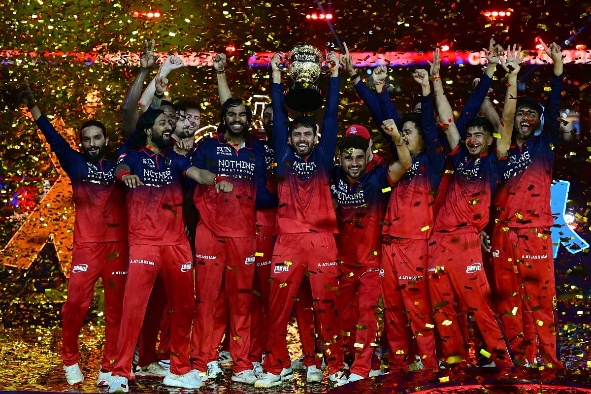 Royal Challengers Bengaluru cricket players celebrate with the trophy after winning the 2026 Indian Premier League (IPL) T20 final match against Gujarat Titans at the Narendra Modi Stadium in Ahmedabad on June 1, 2026.