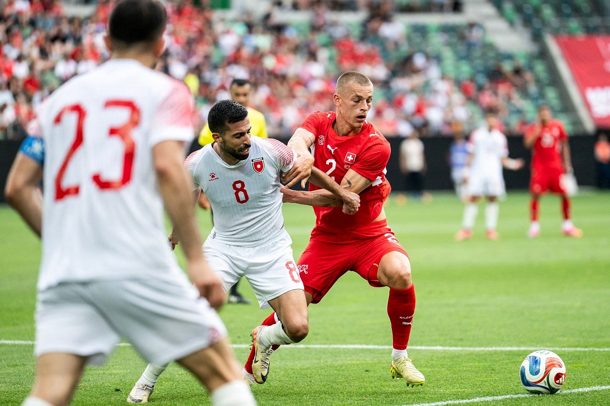 Jordan's midfielder #8 Noor Al Rawabdeh (C) fights for the ball with Switzerland's defender #2 Miro Muheim (R) during a friendly match between Switzerland and Jordan ahead of the 2026 FIFA World Cup football tournament at the Kybunpark stadium, in St. Gallen on May 31, 2026.