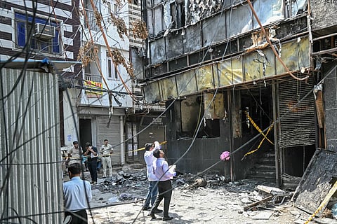 Forensics team members take photographs of the site following a fire that broke out at a hotel in New Delhi on June 3, 2026.