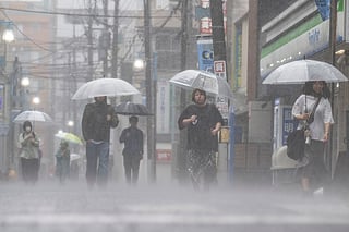 People commute in heavy rain brought by severe tropical storm Jangmi in Kawasaki, Kanagawa prefecture on June 3, 2026.