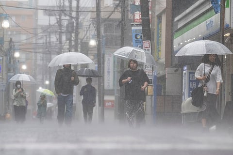 People commute in heavy rain brought by severe tropical storm Jangmi in Kawasaki, Kanagawa prefecture on June 3, 2026.
