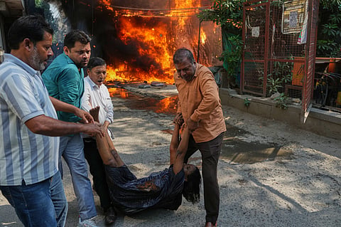 Local people rescue a foreign national from a hotel fire in New Delhi on June 3, 2026.  