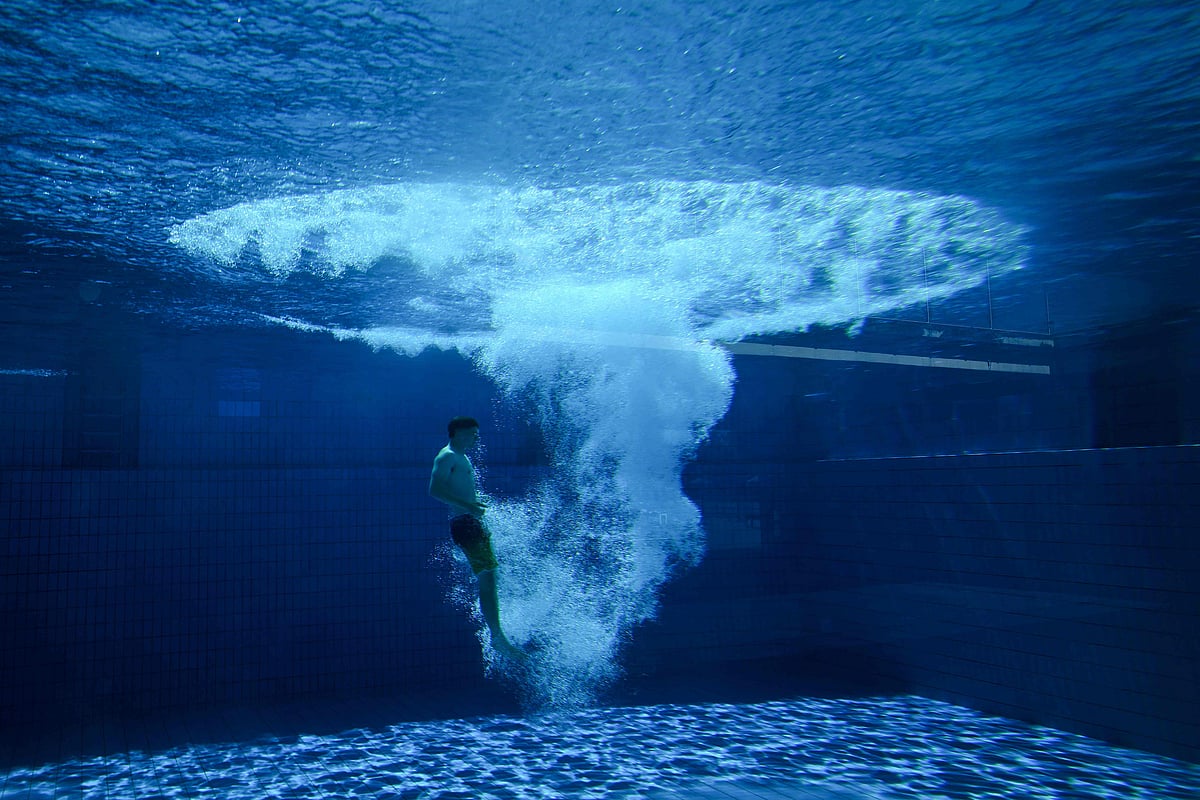 Escaping the heat in style — a young man cuts through the water after diving from a 10-metre platform in Essen during Germany's unseasonably warm weather.