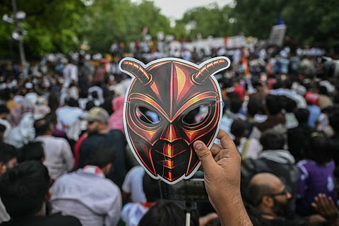 A Cockroach Janta Party (CJP) supporter holds a cockroach mask during a protest over alleged irregularities in the country's major examinations, in New Delhi on June 6, 2026.