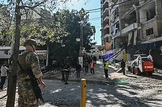 A Lebanese soldier stands guard as first responders work at the site of an Israeli airstrike targeting apartments in a residential building in Beirut's southern suburbs on June 7, 2026.