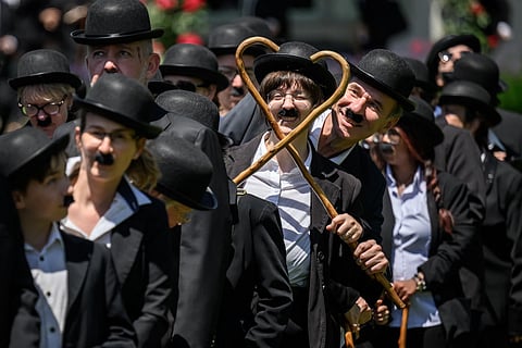 Some 429 people dressed as 'The Tramp' gather for a photograph in front of The Manoir de Ban, the final residence of English film director and actor Charlie Chaplin, during an event to celebrate the 10th anniversary of the Chaplin's World museum in Corsier-sur-Vevey, western Switzerland.