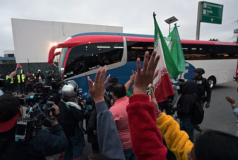 Football fans cheer as Iran's players leave the Tijuana International Airport on a bus in Tijuana, Mexico on June 7, 2026, ahead of the FIFA 2026 World Cup football tournament.