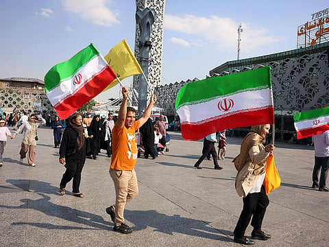People wave Iran's national flags during a rally in support of the country's supreme leader Mojtaba Khamenei.