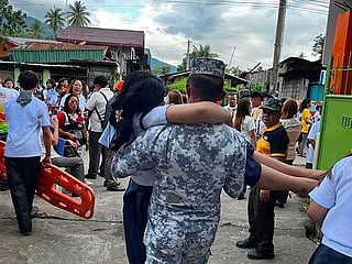 A Coast Guard serviceman carrying an earthquake-affected student in Sta Cruz, Davao del Sur.