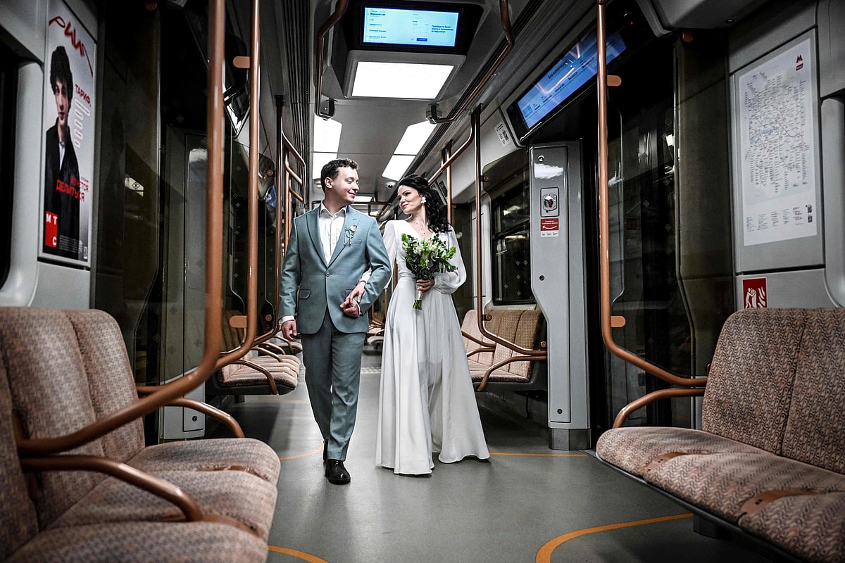 A couple walks through a metro carriage during a wedding ceremony at Mayakovskaya metro station in Moscow.