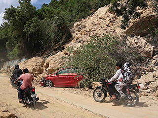 Motorists pass by a landslide following an earthquake in Sarangani province, Philippines, Wednesday, June 10, 2026. 