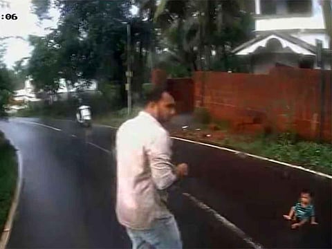 A dramatic moment as conductor Navas runs to rescue an infant spotted crawling on the Kondotty-Valiyaparamba road in Kerala.
