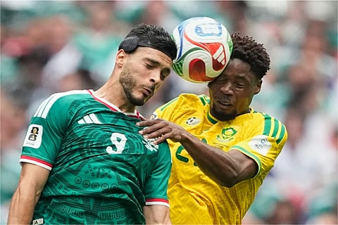 Raul Jimenez jumps for a header with South Africa's Ime Okon.