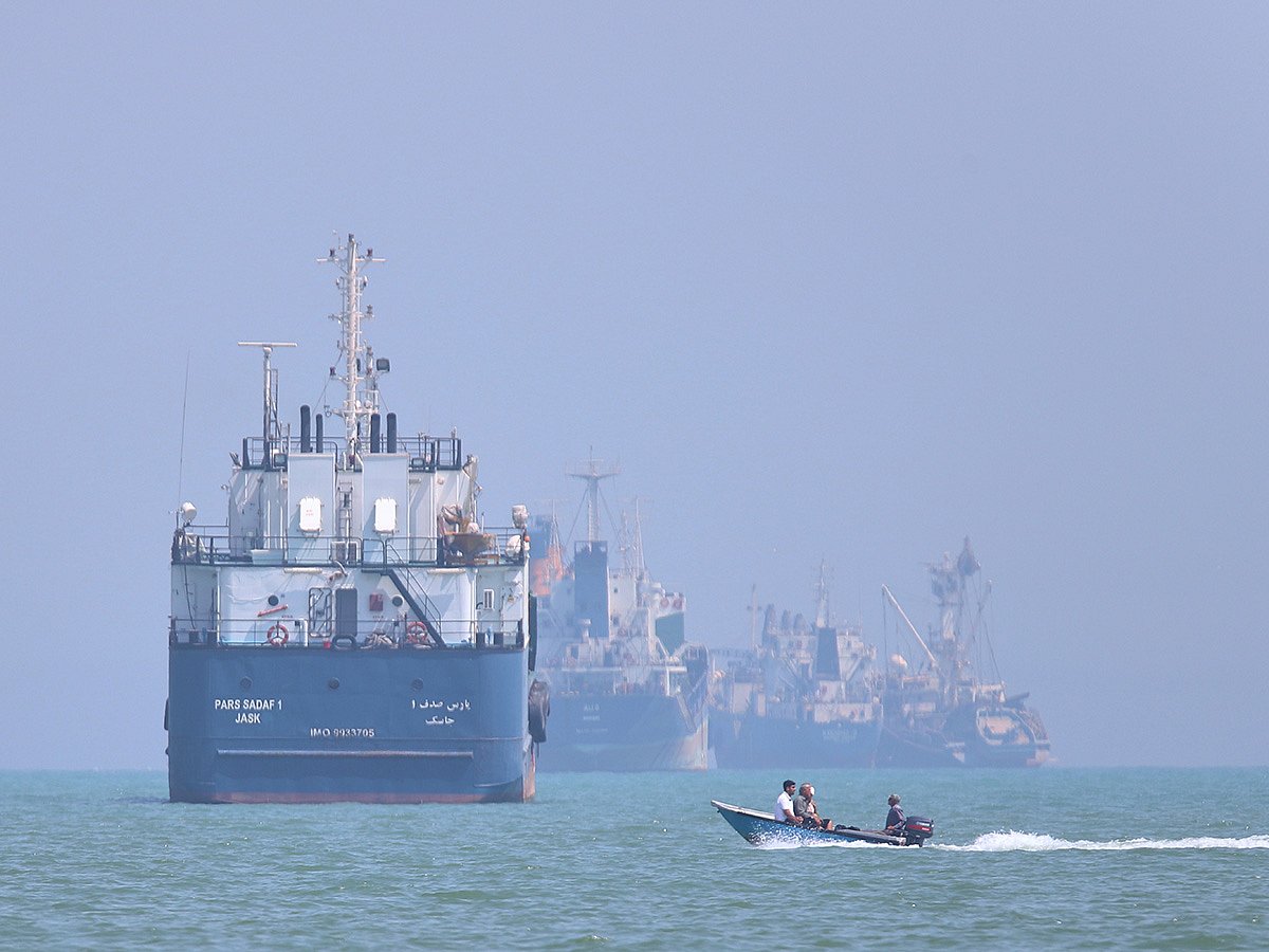 A small motorboat passes anchored vessels in the Strait of Hormuz off Bandar Abbas, Iran, on Thursday, June 11, 2026.