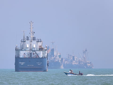 A small motorboat passes anchored vessels in the Strait of Hormuz off Bandar Abbas, Iran, on Thursday, June 11, 2026.