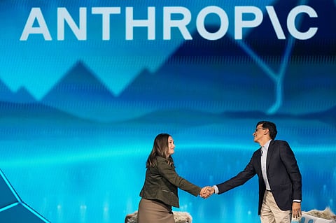 Anthropic co-founder and President Daniela Amodei, left, shakes hands with Snowflake CEO Sridhar Ramaswamy during the keynote presentaton at Snowflake Summit 26 Monday, June 1, 2026, in San Francisco. (AP Photo/Jeff Chiu)