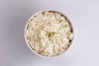 Rinsing rice may help reduce surface contaminants such as arsenic and microplastics, with minimal nutritional impact for most people. 
