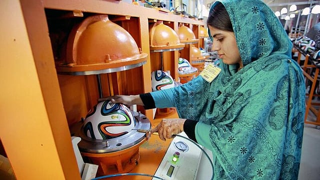 An employee inflating an Adidas AG 'Brazuca' football, used for the 2014 World Cup in Brazil