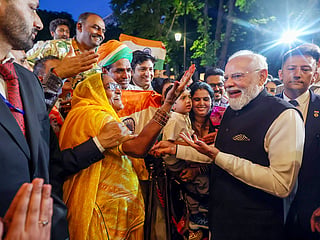 India Prime Minister Narendra Modi interacts with a woman as he receives a warm welcome from the Indian community on arrival, in Paris on Wednesday. 