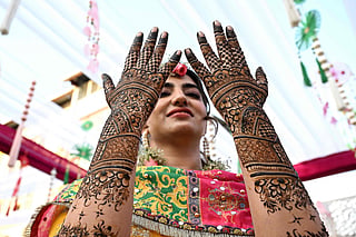A Kashmiri bride admires intricate henna designs on her hands during her wedding celebrations in Srinagar. From lavish wazwan feasts to vibrant cultural performances, Kashmiri weddings are a powerful expression of heritage, faith and community. These generations-old traditions continue to thrive across the valley, supporting thousands of livelihoods, from chefs and decorators to artisans, servers and performers.