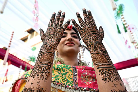 A Kashmiri bride admires intricate henna designs on her hands during her wedding celebrations in Srinagar. From lavish wazwan feasts to vibrant cultural performances, Kashmiri weddings are a powerful expression of heritage, faith and community. These generations-old traditions continue to thrive across the valley, supporting thousands of livelihoods, from chefs and decorators to artisans, servers and performers.