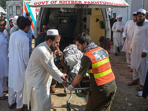 Volunteers transfer the body of a victim, killed in twin roadside blasts, to a hospital in Bannu.