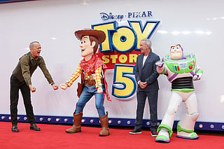 Tom Hanks, left, and Tim Allen pose for photographers with people costumed as the characters Woody and Buzz Lightyear upon arrival at a launch event for the film 'Toy Story 5' on Thursday, May 28, 2026, in London. (Photo by Millie Turner/Invision/AP)