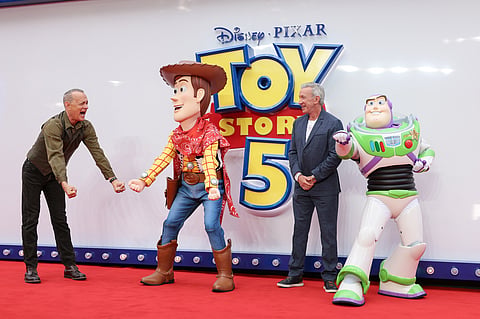 Tom Hanks, left, and Tim Allen pose for photographers with people costumed as the characters Woody and Buzz Lightyear upon arrival at a launch event for the film 'Toy Story 5' on Thursday, May 28, 2026, in London. (Photo by Millie Turner/Invision/AP)