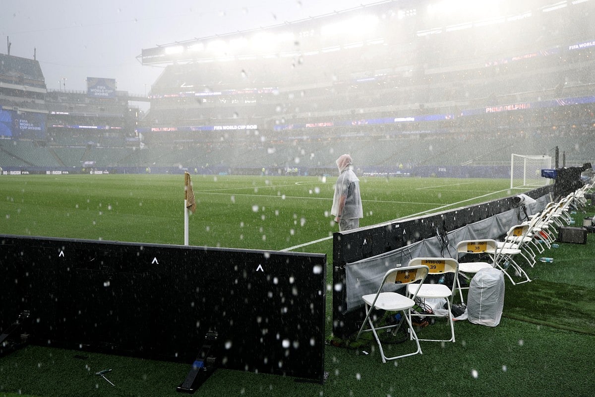 A photographer wears a raincoat as the 2026 World Cup Group I football match between France and Iraq is suspended due adverse weather at the Philadelphia Stadium in Philadelphia on June 22, 2026.