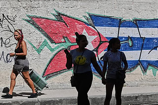 People walk past graffiti in the colors of the Cuban flag in Havana, Cuba, Wednesday, June 17, 2026.