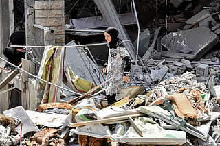 A woman inspects the rubble of a collapsed building in the town of Nabatieh al-Fawqa in southern Lebanon on June 23, 2026.