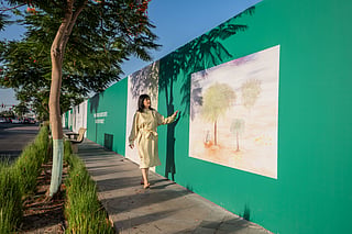 Solimar Miller in front of Flora of Light a series of 12 original artworks celebrating the UAE's indigenous flora and fauna