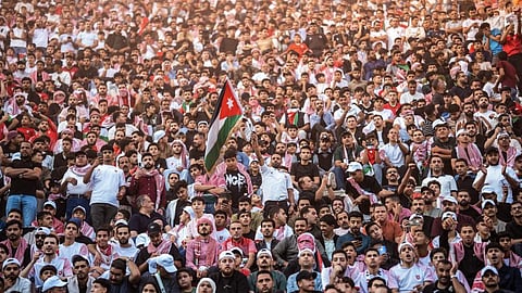 : Jordanian football fans watching on giant screens their national team's 2026 World Cup Group J football match against Algeria at Amman's Roman amphitheatre early on Tuesday.