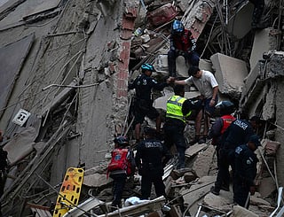 Rescuers evacuate a person from a collapsed building following an earthquake in Caracas.