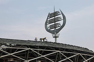Workers are seen at the construction site of an international cricket stadium with Hindu god Shiva-themed architecture, including trident-shaped floodlights, on the outskirts of Varanasi on June 25, 2026.